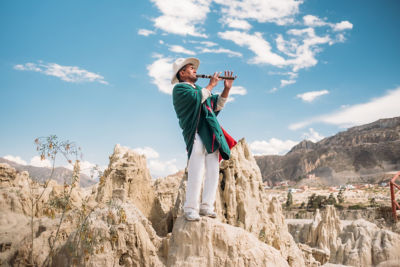 Bolivia local musician playing on the top of the mountain
